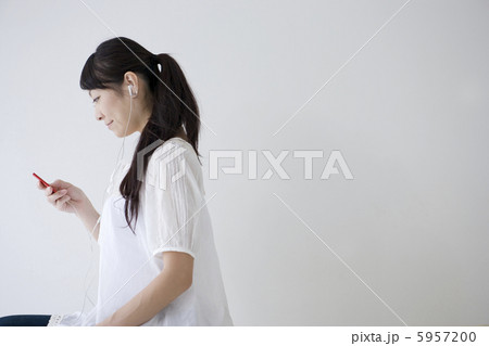 ＭＰ3プレーヤーで音楽を聴く女性の横顔 5957200