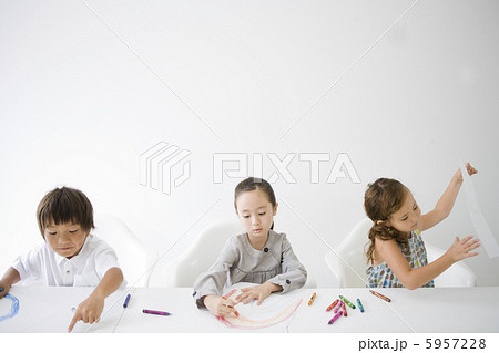 テーブルに並びクレヨンで絵を描く子供三人 5957228