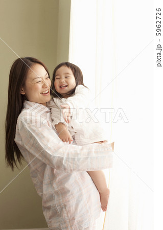 娘を抱きカーテンを開ける母親 5962726