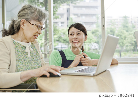 介護施設でパソコンを使うシニア女性と介護士 介護施設でパソコンを使うシニア女性と介護士 5962841