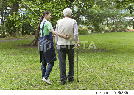 公園を散歩するシニア男性と介護士 公園を散歩するシニア男性と介護士 5962869