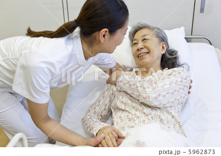 女性をベッドから起こす介護士 5962873