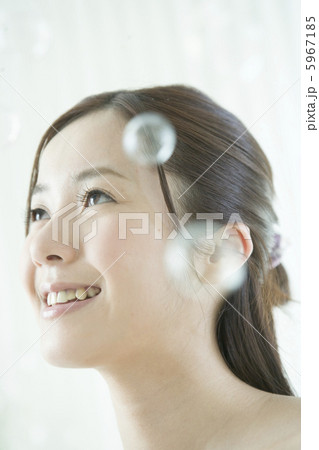 見上げる笑顔の20代女性とシャボン玉 5967185
