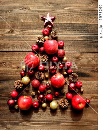 りんごと赤いクリスマスオーナメントのツリーの写真素材