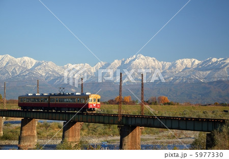 白銀の立山連峰を背景に走る京阪特急カラーの地鉄電車 5977330