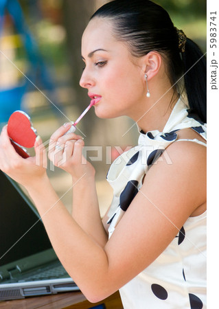 Pretty woman applying cosmetics Pretty woman applying cosmetics 5983741