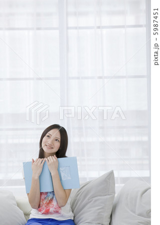 アルバムを抱え思い出にふける20代女性 アルバムを抱え思い出にふける20代女性 5987451