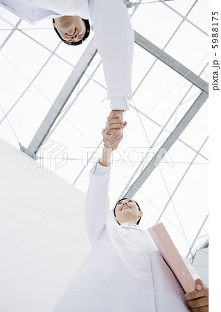 握手をする白衣の男性と女性 5988175