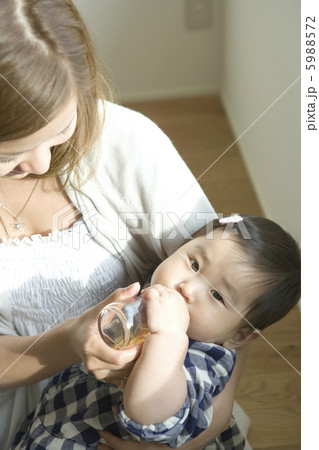 母親に抱かれて麦茶を飲む赤ちゃん 5988572