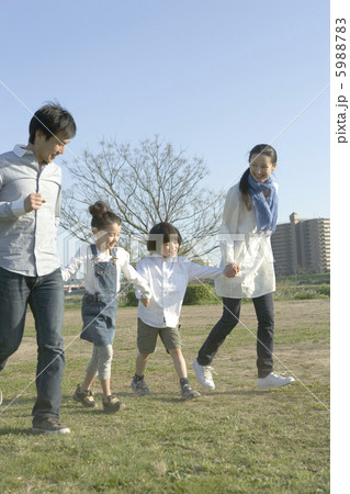 野原を歩く家族4人 5988783
