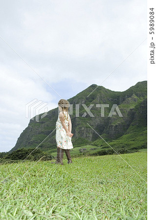 後ろに手を組み野原に立つ女の子の後姿 5989084