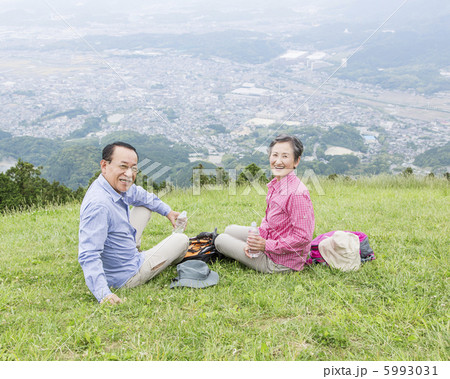 草原に座る日本人のシニア夫婦 草原に座る日本人のシニア夫婦 5993031