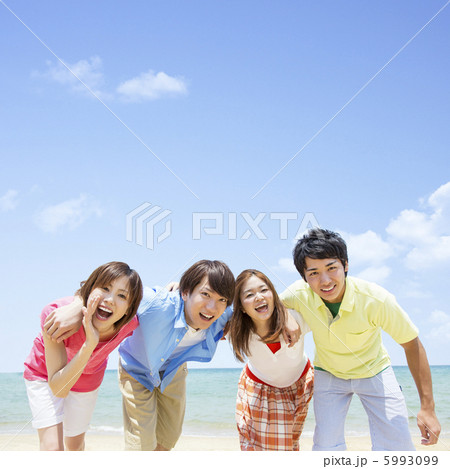 海辺で肩を組む4人の若者の写真素材 海辺で肩を組む4人の若者の写真素材