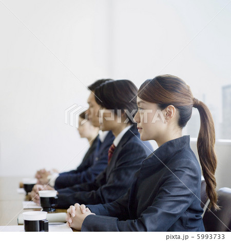 並んで座るスーツ姿の男女の写真素材