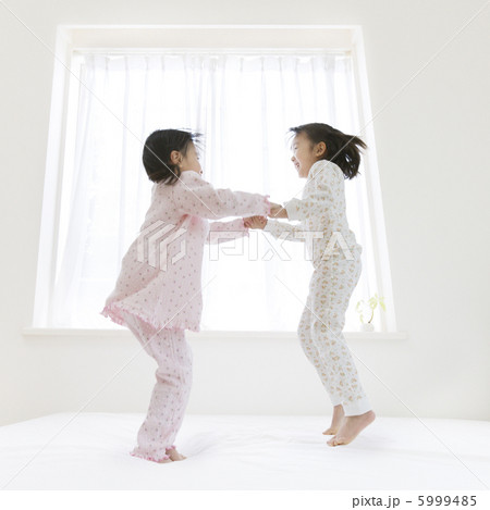 ベッドの上でジャンプする２人の女の子 5999485