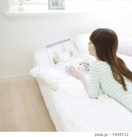 寝ころんでパソコンを操作する女性 5999712