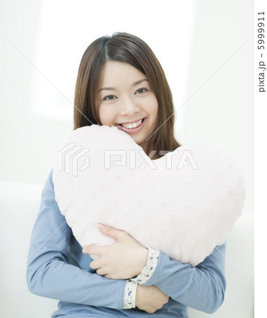 ハート型のクッションを抱く女性 5999911