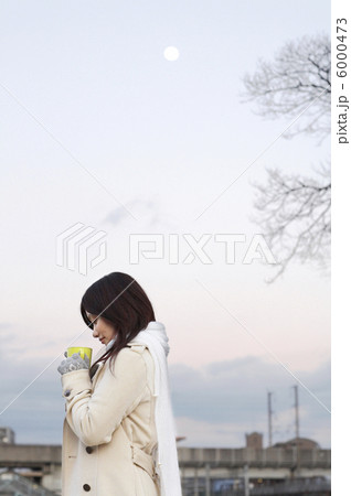 満月の夕暮れにホットドリンクを飲む女性 6000473