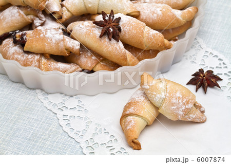 Freshly baked croissants with powdered sugar. 6007874