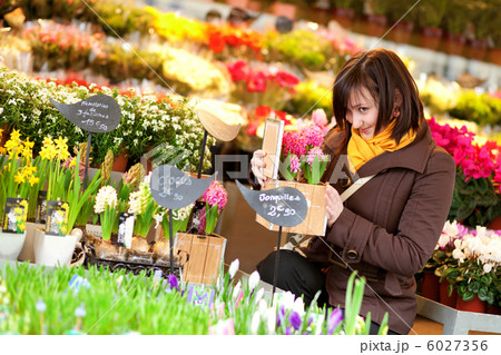 Beautiful young girl buying flowers at flower market 6027356