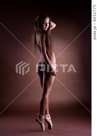 Sexy girl in dark stand topless on ballet pointes 6032775