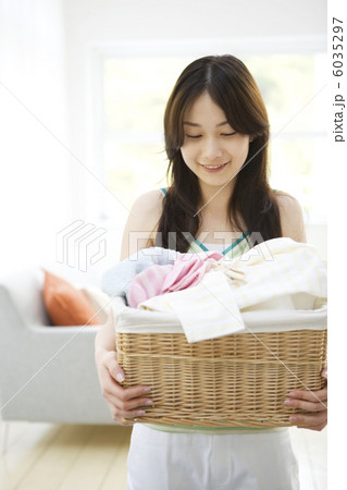 洗濯物の入ったかごを持っている女性 6035297
