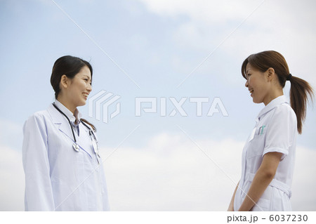 青空の下で話をする女医と看護師 6037230