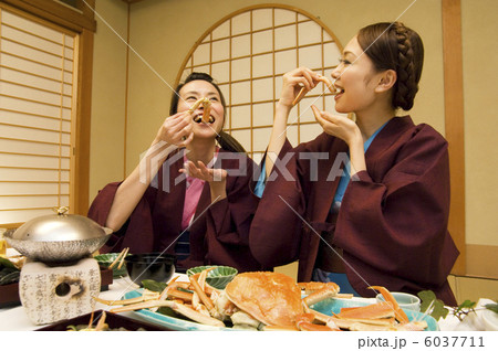 蟹身を食べている浴衣の女性2人 6037711