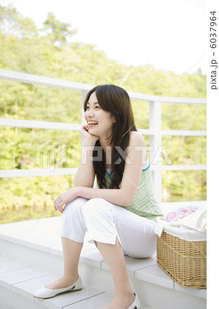 洗濯物を取り込んで休憩する女性 洗濯物を取り込んで休憩する女性 6037964