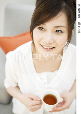 ソファに座ってティーを飲もうとする女性 6038618