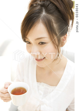 ソファに座ってティーを飲もうとする女性 6038643