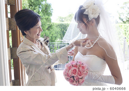 ベールダウンをする花嫁と母の写真素材