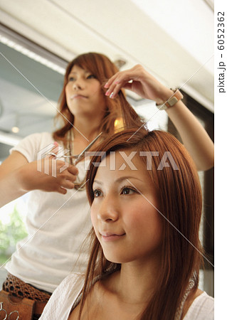 髪をカットされる女性と美容師 6052362