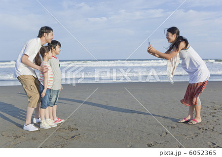 海岸で写真撮影をする家族４人 6052365