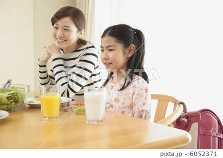 食卓に並んで座る母親と娘 6052371