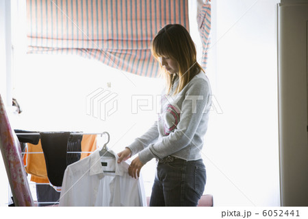 室内で洗濯物を干す女性 室内で洗濯物を干す女性 6052441