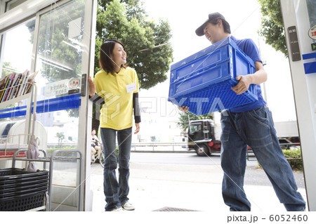 納品に来た男性と入口に立つ女性店員 6052460