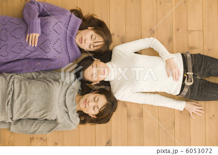 フローリングの上に寝そべる女性３人 6053072