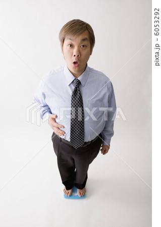 体重計に乗る中年男性 6053292