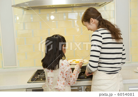 キッチンでお手伝いをする娘と母親 キッチンでお手伝いをする娘と母親 6054081
