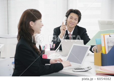 電話をしながら部下を眺める上司 6054082