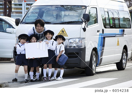 バスの前でホワイトボードを持つ幼稚園児と幼稚園教諭 バスの前でホワイトボードを持つ幼稚園児と幼稚園教諭 6054238