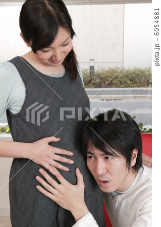 妊婦のおなかに耳をあてる男性 6054881