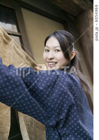 のれんを掛ける女性店員 6054969