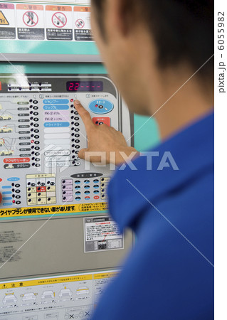 洗車機のボタンを押す男性店員 6055982