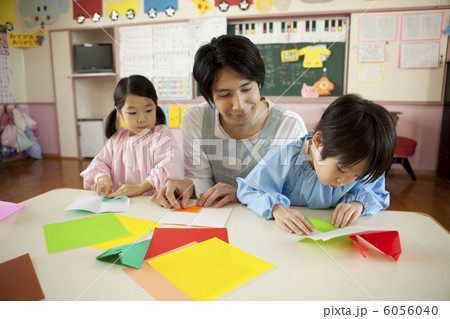 折り紙をする子供２人と幼稚園教諭 6056040