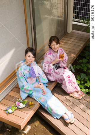 縁側でお茶を飲む浴衣姿の若い女性2人 6056176