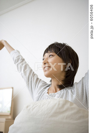 ベッドで伸びをする20代主婦 6056406