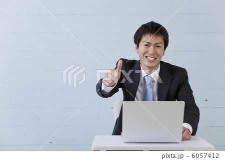 デスクに座る笑顔の若い男性 デスクに座る笑顔の若い男性 6057412