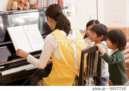 ピアノを弾く保育士と子供３人 6057716